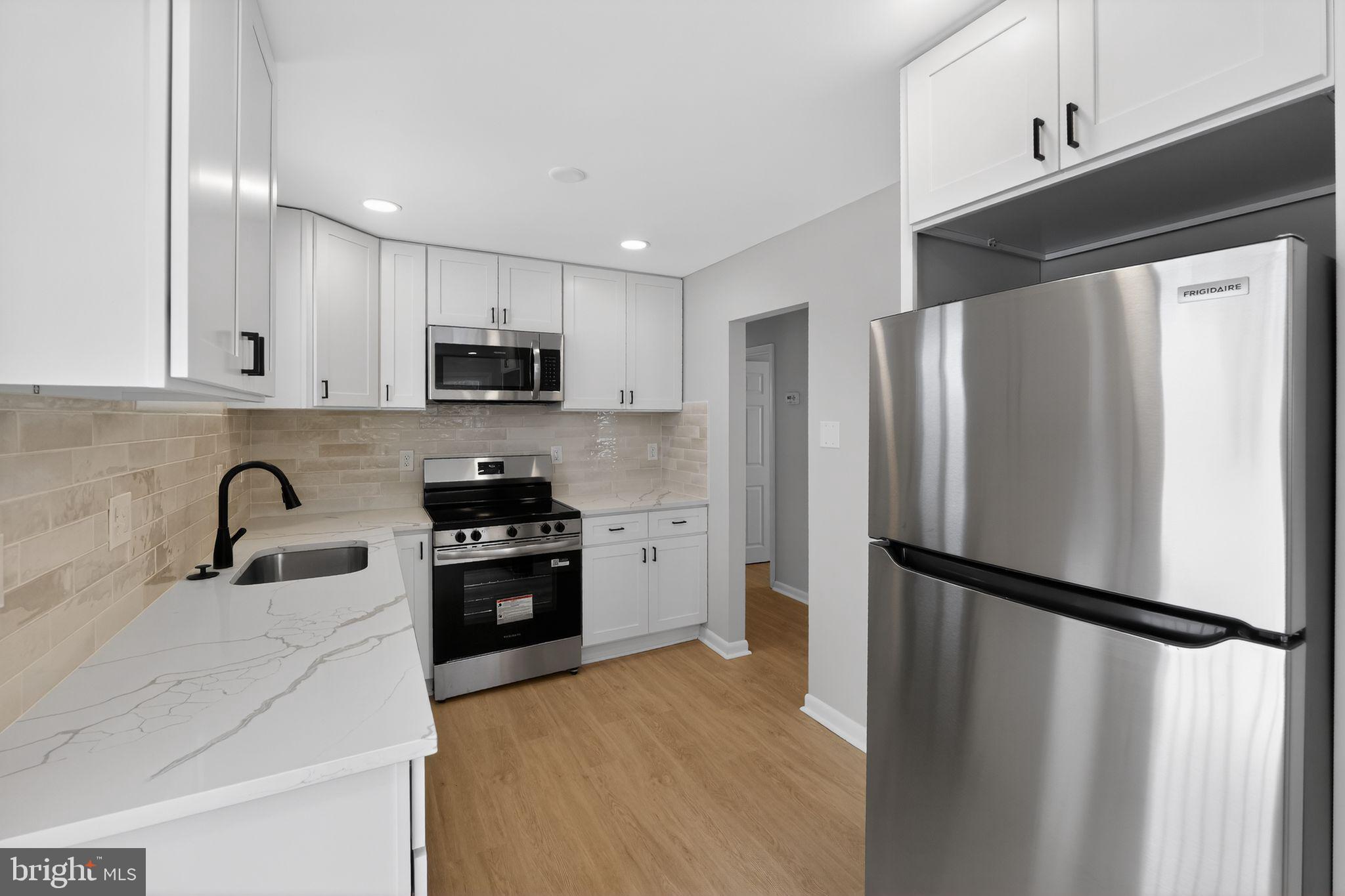 203 Antietam Road Baltimore, MD 21221 - Photo 7 of 33 a kitchen with a refrigerator sink and stainless steel appliances