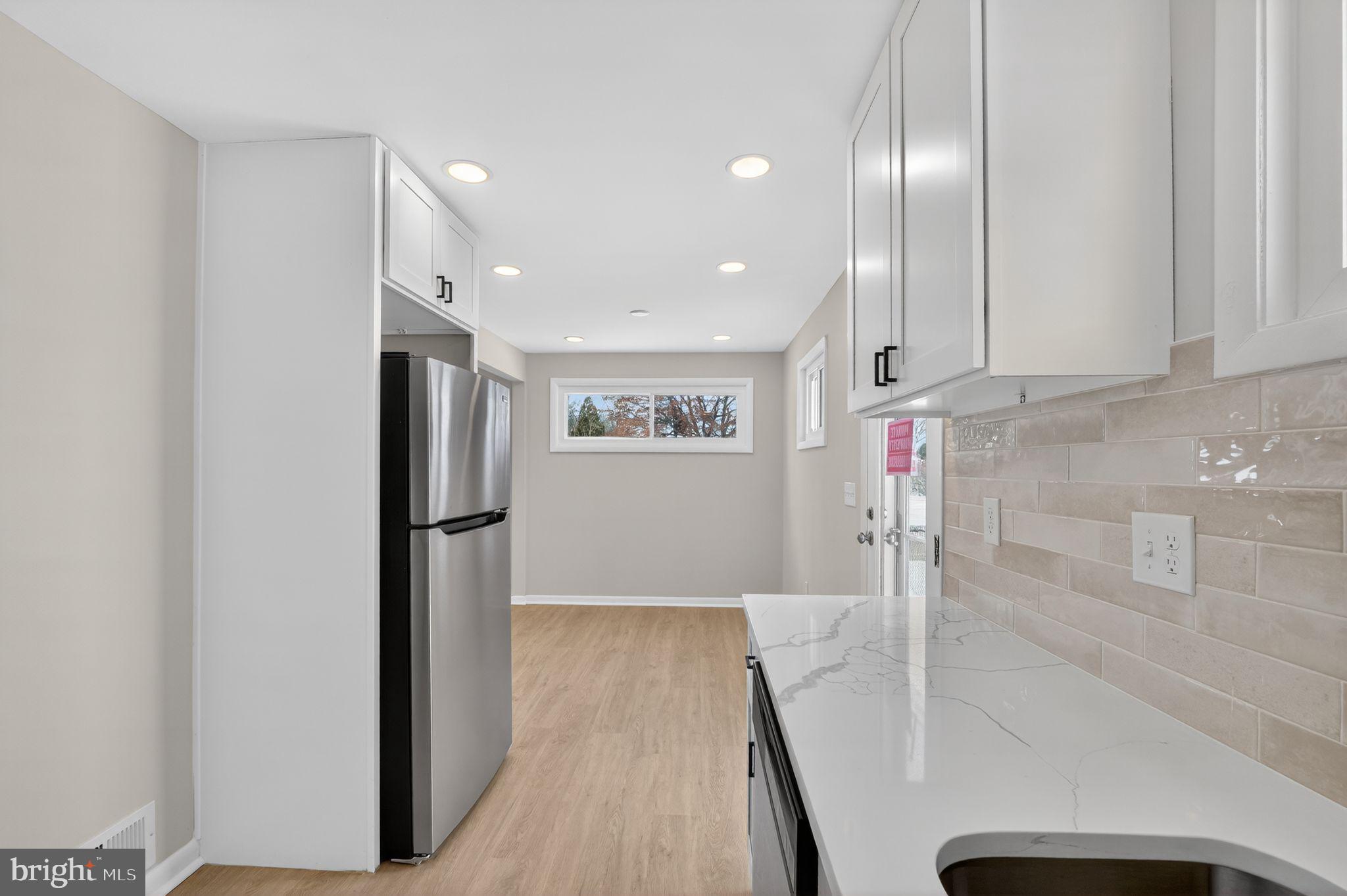 203 Antietam Road Baltimore, MD 21221 - Photo 8 of 33 a view of a kitchen with refrigerator and wooden floor