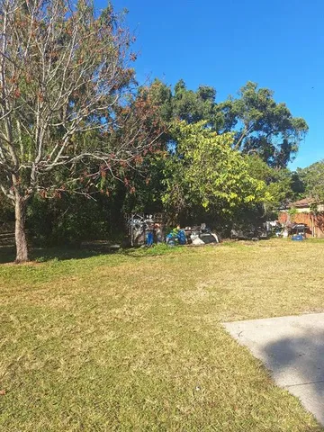 a view of yard with swimming pool and trees