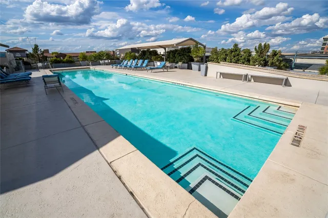 a view of swimming pool with lawn chairs and a couple of lawn chairs