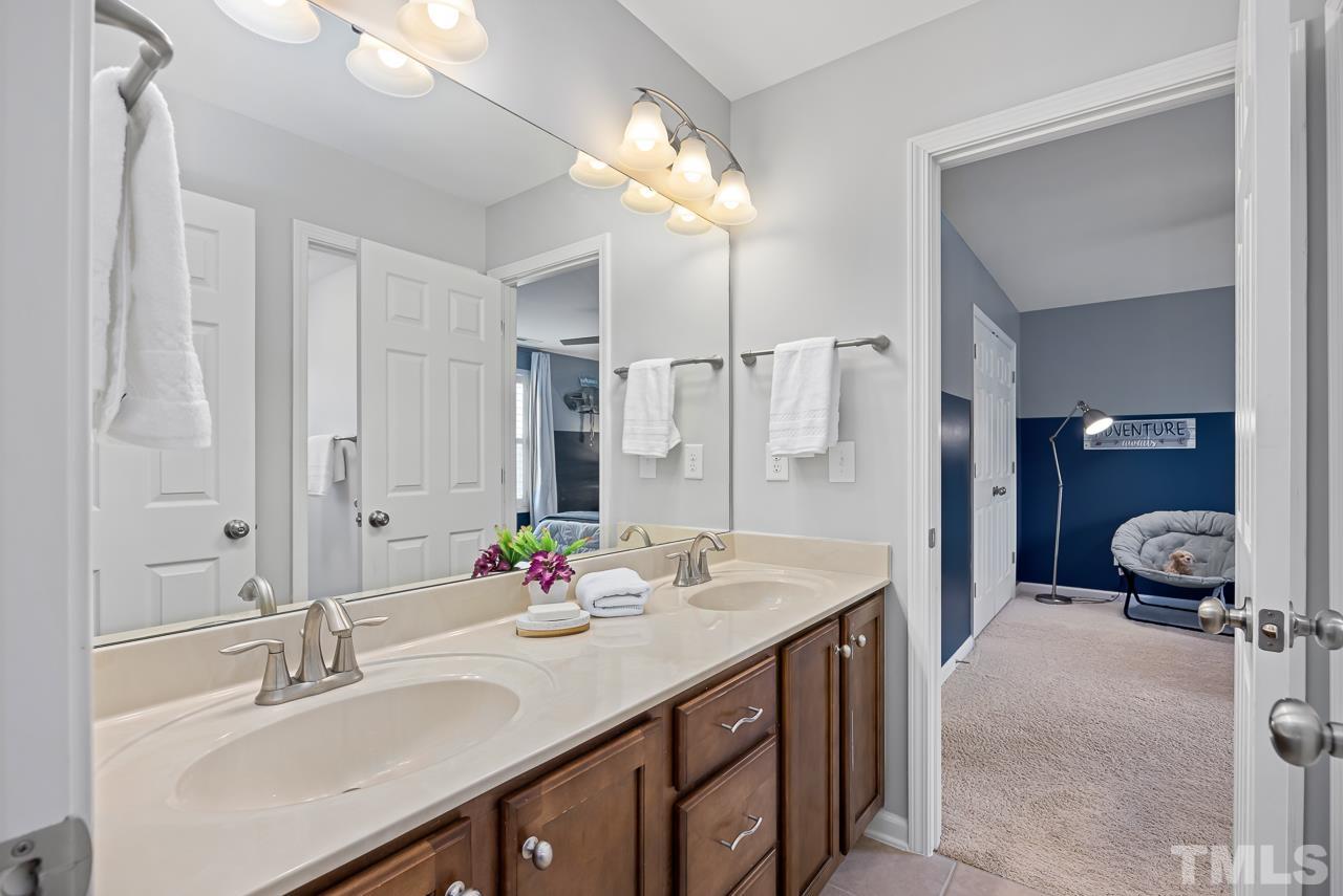 2901 Red Grape Drive Raleigh, NC 27607 - Photo 24 of 43 a bathroom with a sink double vanity and a mirror