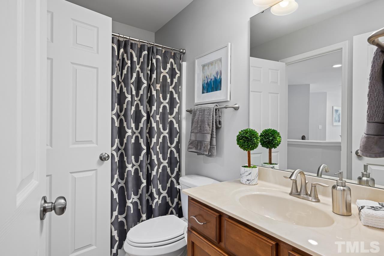 2901 Red Grape Drive Raleigh, NC 27607 - Photo 26 of 43 a bathroom with a sink toilet a mirror and shower curtain