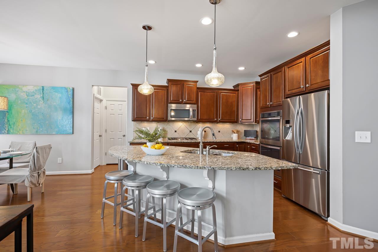 2901 Red Grape Drive Raleigh, NC 27607 - Photo 7 of 43 a kitchen with stainless steel appliances granite countertop a sink refrigerator and cabinets
