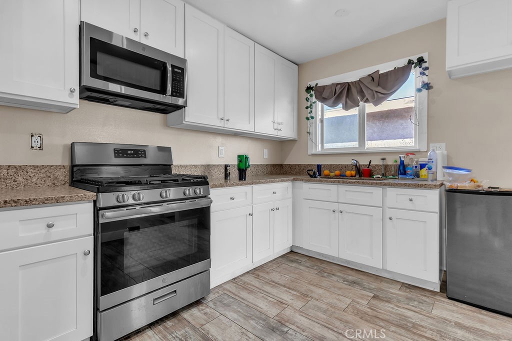9734 Terradell Street Pico Rivera, CA 90660 - Photo 6 of 10 a kitchen with cabinets stainless steel appliances a sink and a stove
