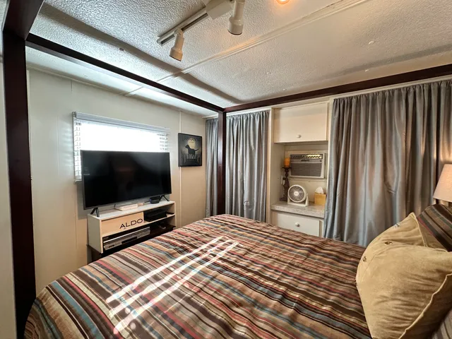 a bedroom with a bed and a flat screen tv