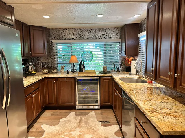 a kitchen with stainless steel appliances granite countertop sink stove and refrigerator