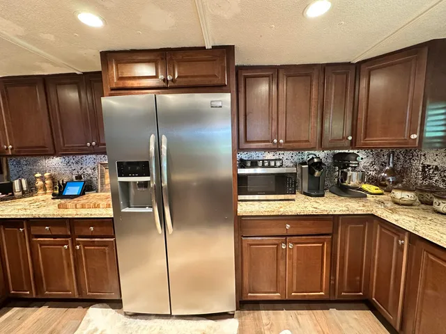 a kitchen with granite countertop a refrigerator and a sink