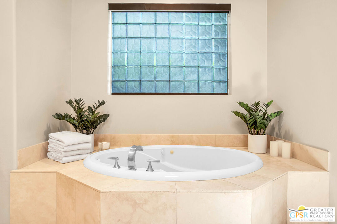 39700 Keenan Drive Rancho Mirage, CA 92270 - Photo 53 of 69 a close view of a sink a faucet a potted plant and a glass door