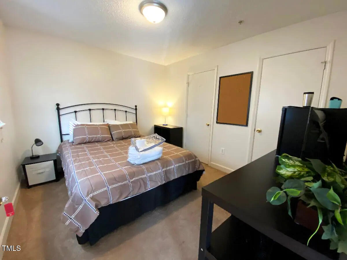 303 Smith Level Road, Unit E33 Chapel Hill, NC 27516 - Photo 10 of 25 a bedroom with a bed window and table