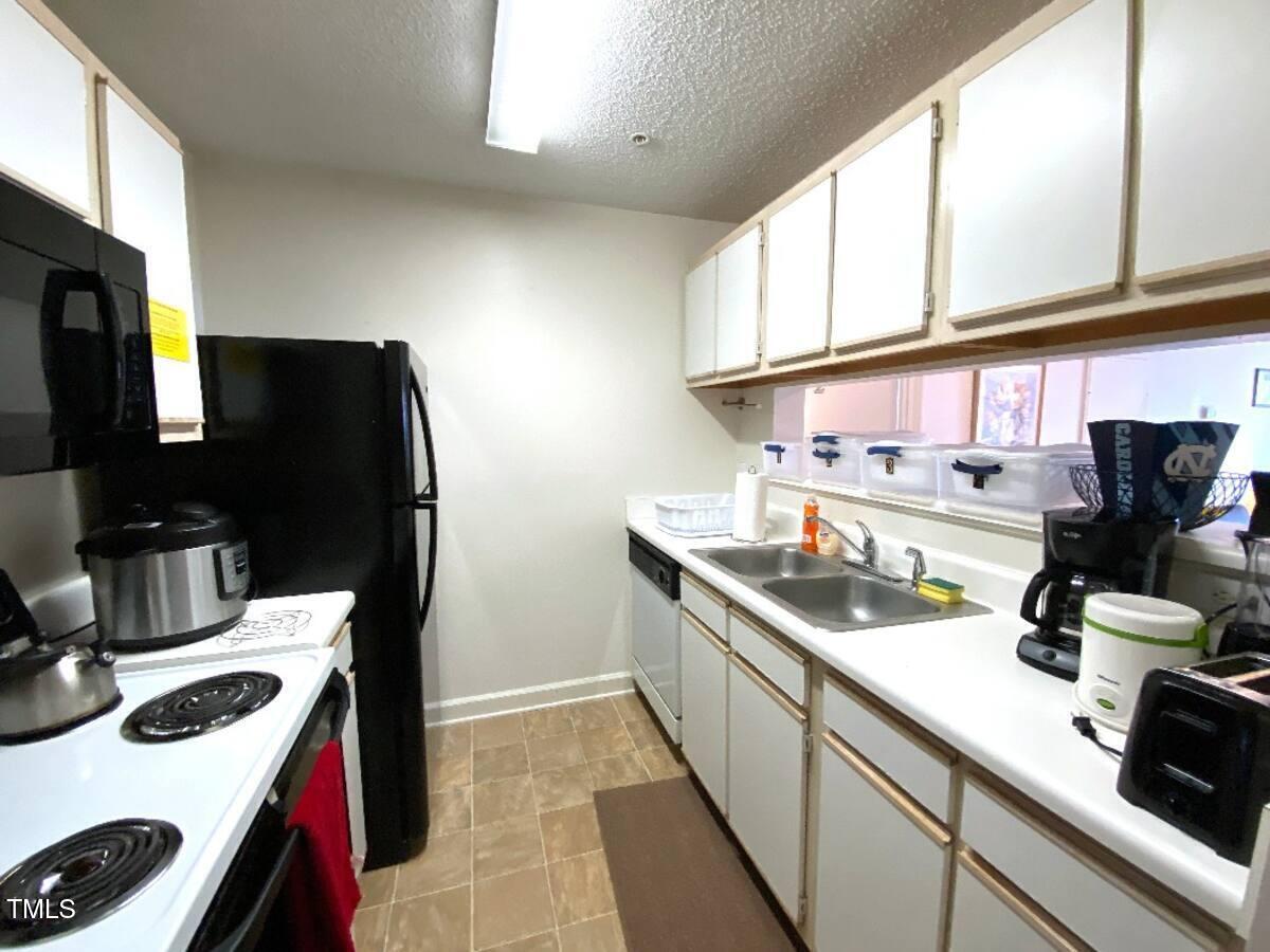 303 Smith Level Road, Unit E33 Chapel Hill, NC 27516 - Photo 15 of 25 a kitchen with a sink stove and refrigerator
