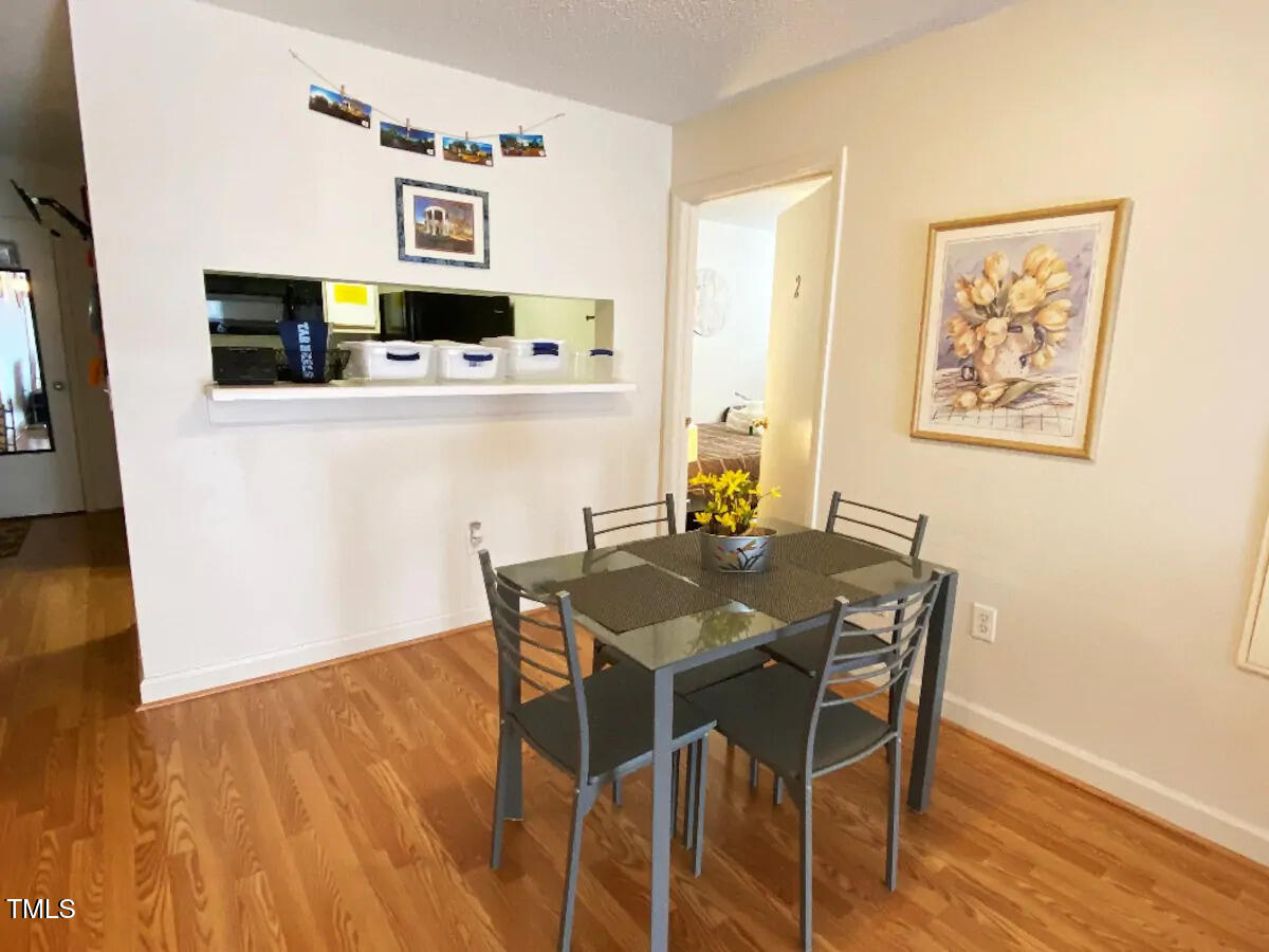 303 Smith Level Road, Unit E33 Chapel Hill, NC 27516 - Photo 4 of 25 a dining room with furniture and wooden floor