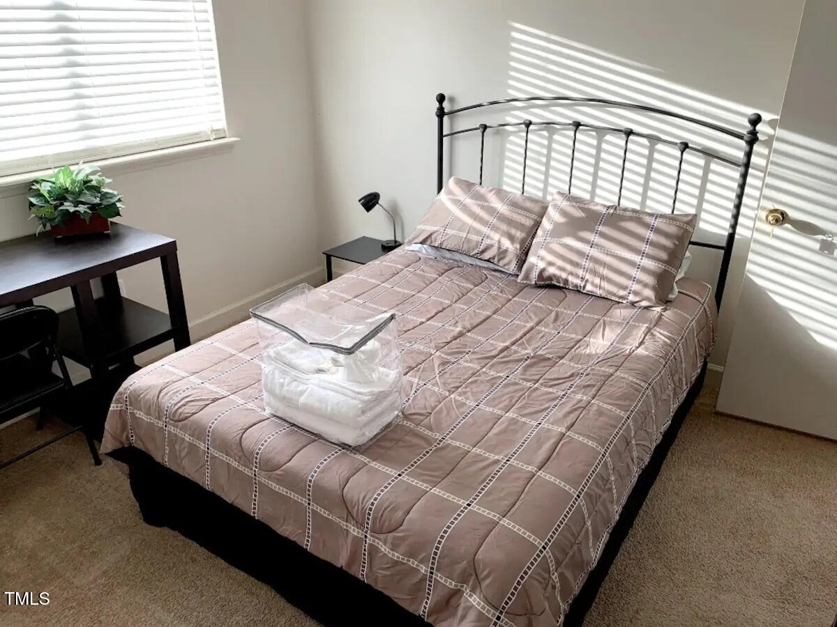 303 Smith Level Road, Unit E33 Chapel Hill, NC 27516 - Photo 6 of 25 a bedroom with a bed table chair and a window