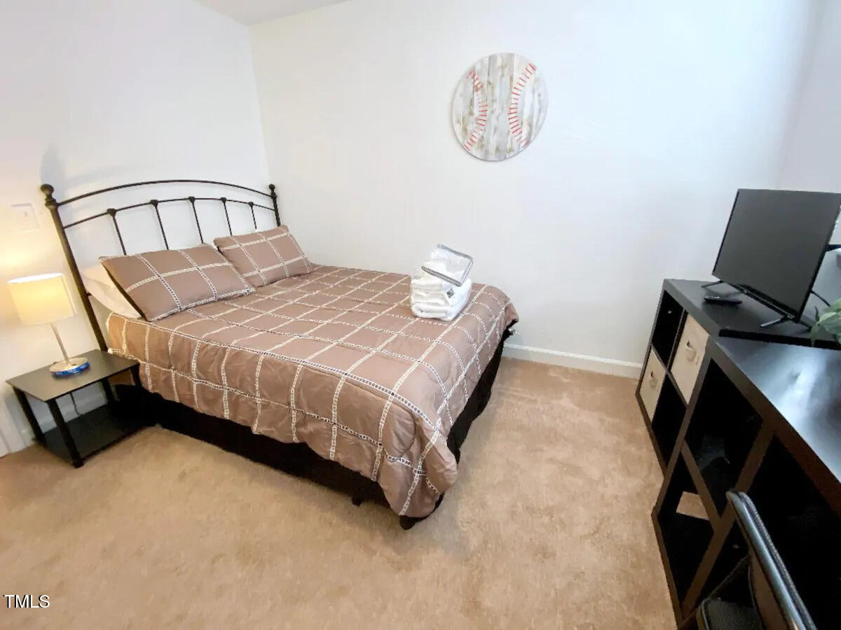 303 Smith Level Road, Unit E33 Chapel Hill, NC 27516 - Photo 7 of 25 a bedroom with a bed and a chair