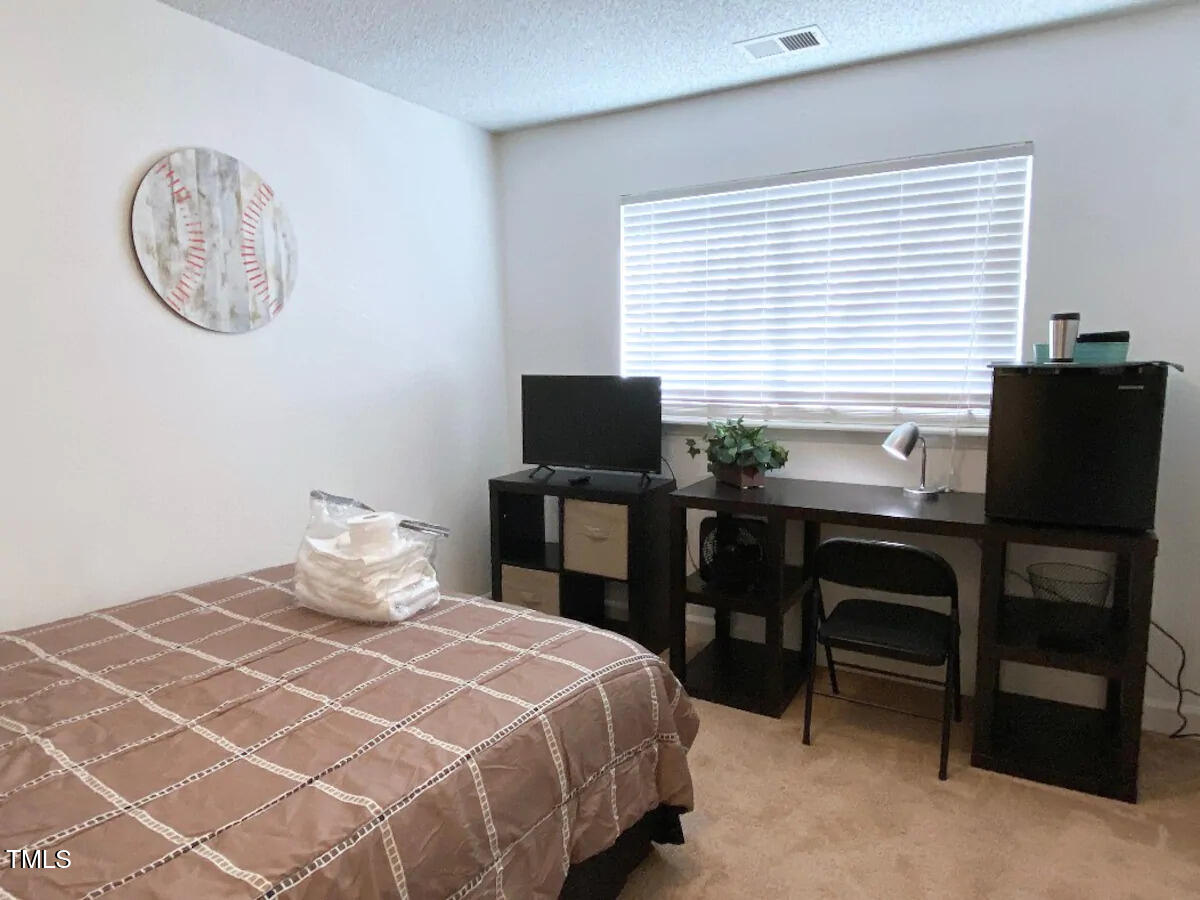 303 Smith Level Road, Unit E33 Chapel Hill, NC 27516 - Photo 8 of 25 a bedroom with a bed and a desk