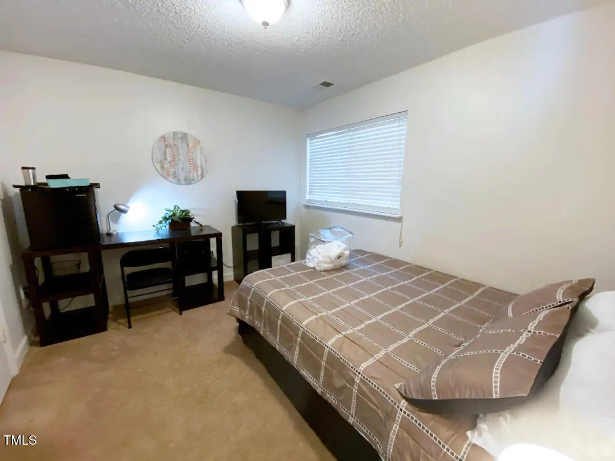 303 Smith Level Road, Unit E33 Chapel Hill, NC 27516 - Photo 9 of 25 a bedroom with a bed and a chandelier