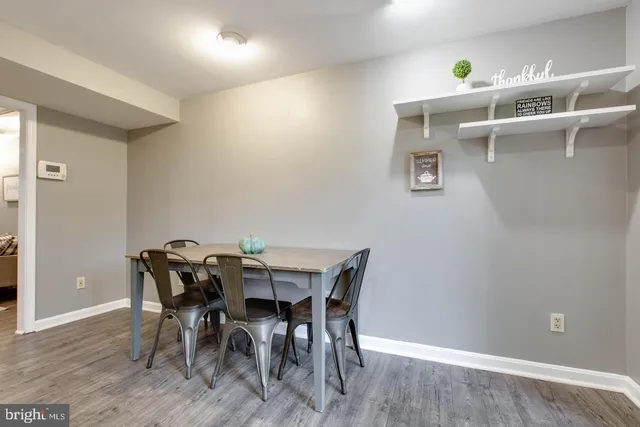 a kitchen with stainless steel appliances granite countertop a refrigerator a sink dishwasher a stove and white cabinets with wooden floor