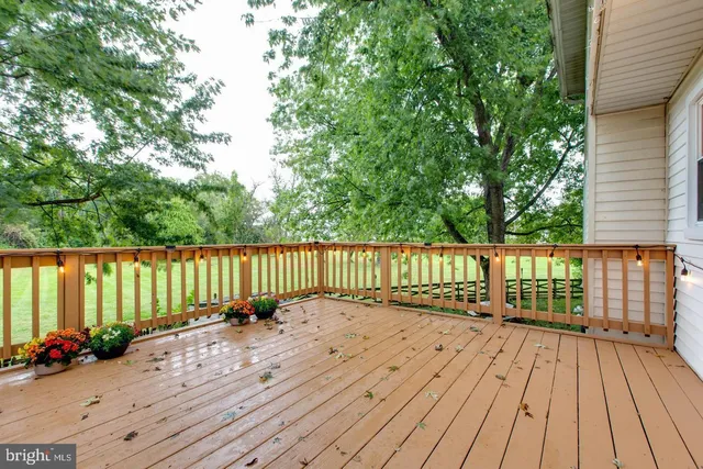 a porch with a table and chairs next to a yard