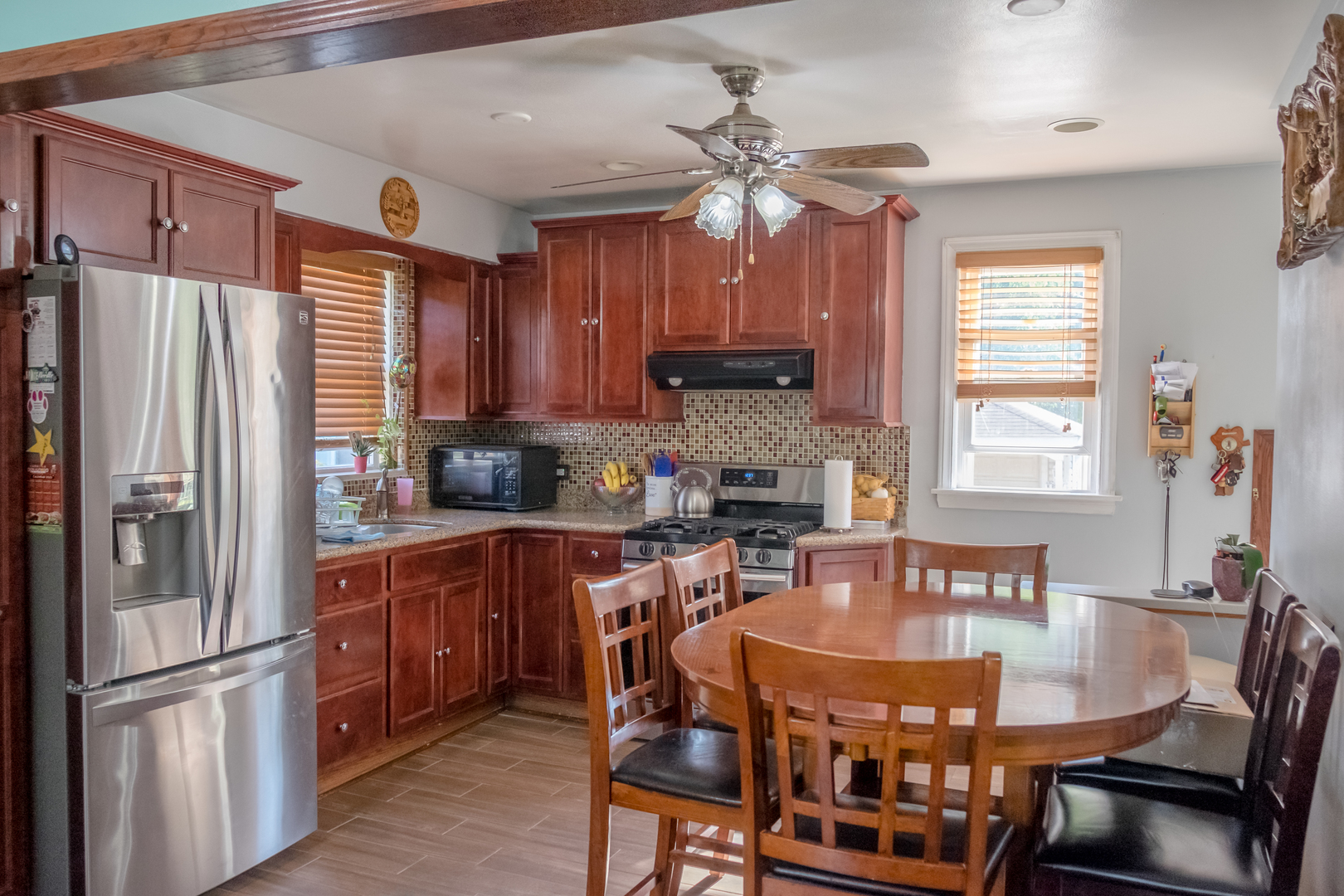 4619 Butterfield Road Hillside, IL 60162 - Photo 10 of 52 a kitchen with stainless steel appliances granite countertop a stove a refrigerator a kitchen island a dining table and chairs