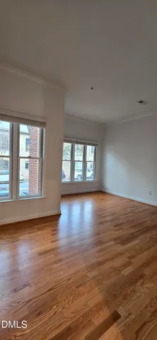 a view of big room with wooden floor and windows