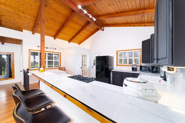 a large white kitchen with sink and furniture