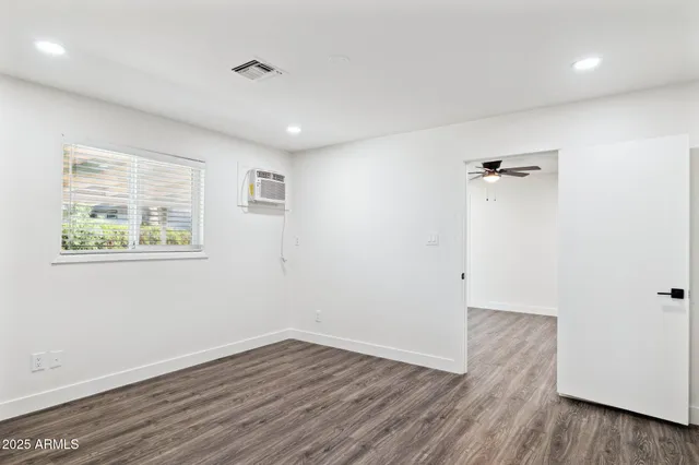 an empty room with wooden floor and a window