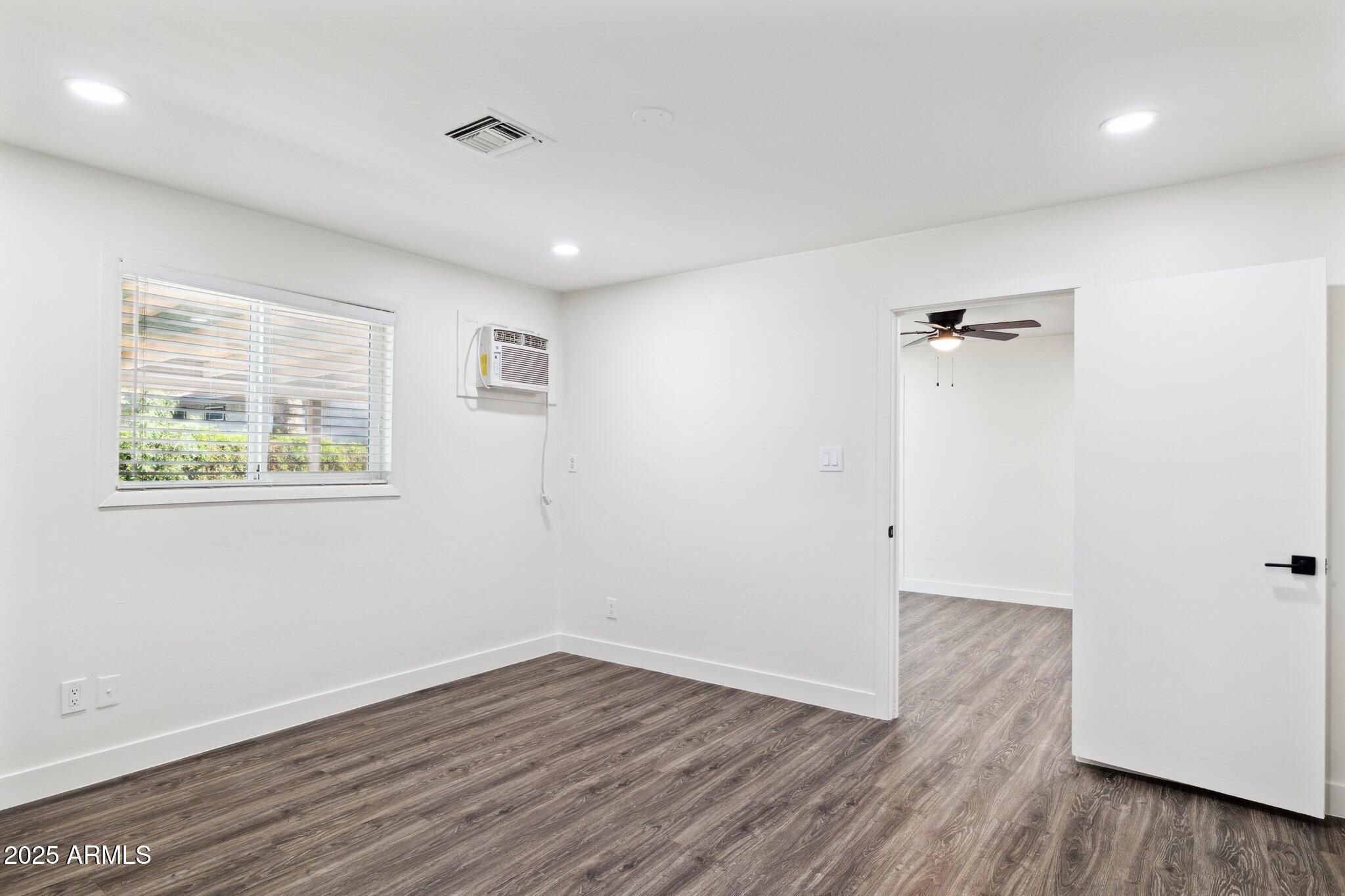 1542 East Turquoise Avenue, Unit 1 Phoenix, AZ 85020 - Photo 13 of 25 an empty room with wooden floor and a window