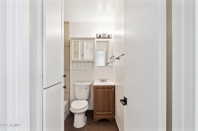 a bathroom with a toilet sink and a mirror