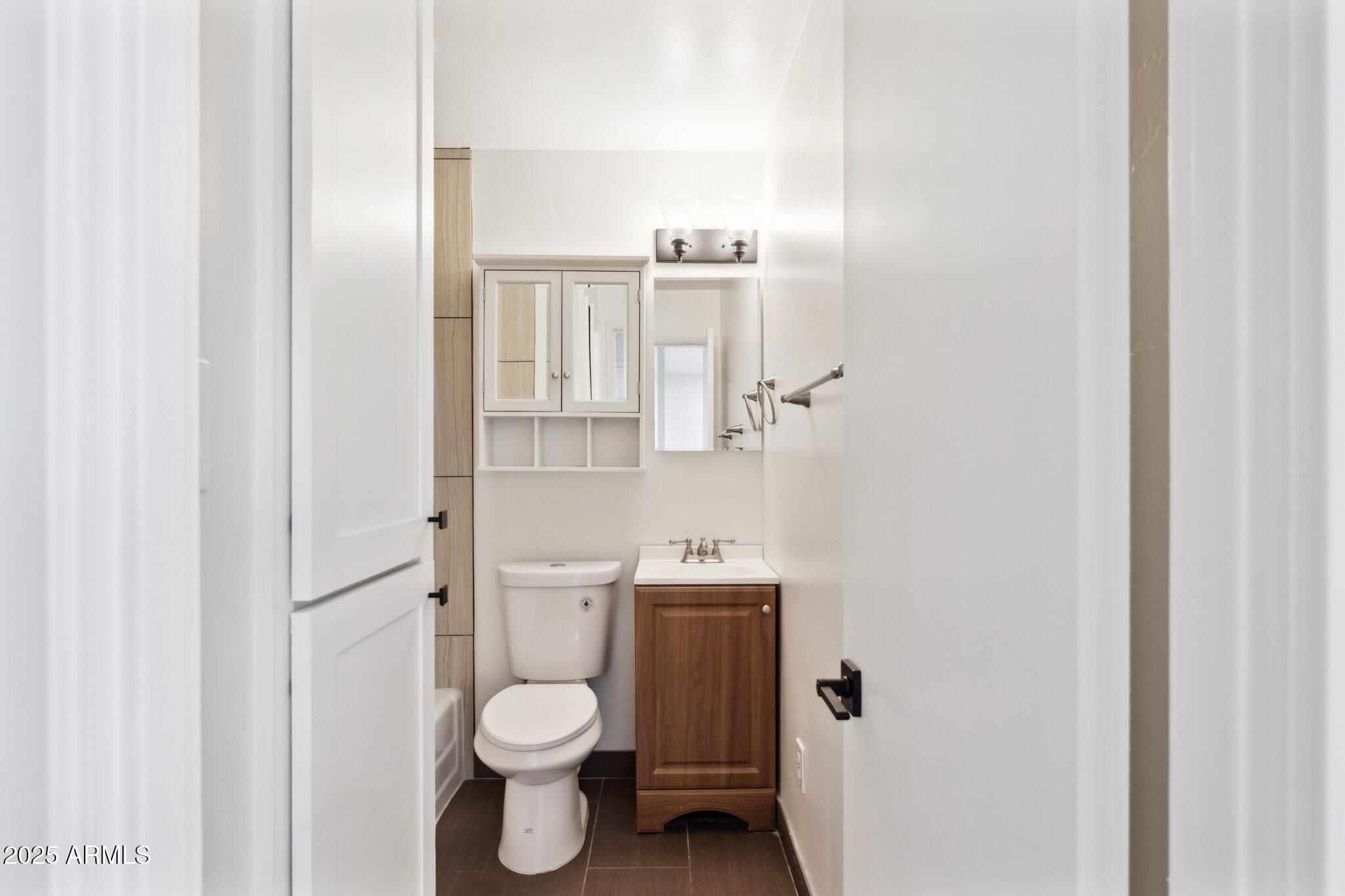 1542 East Turquoise Avenue, Unit 1 Phoenix, AZ 85020 - Photo 14 of 25 a bathroom with a toilet sink and a mirror