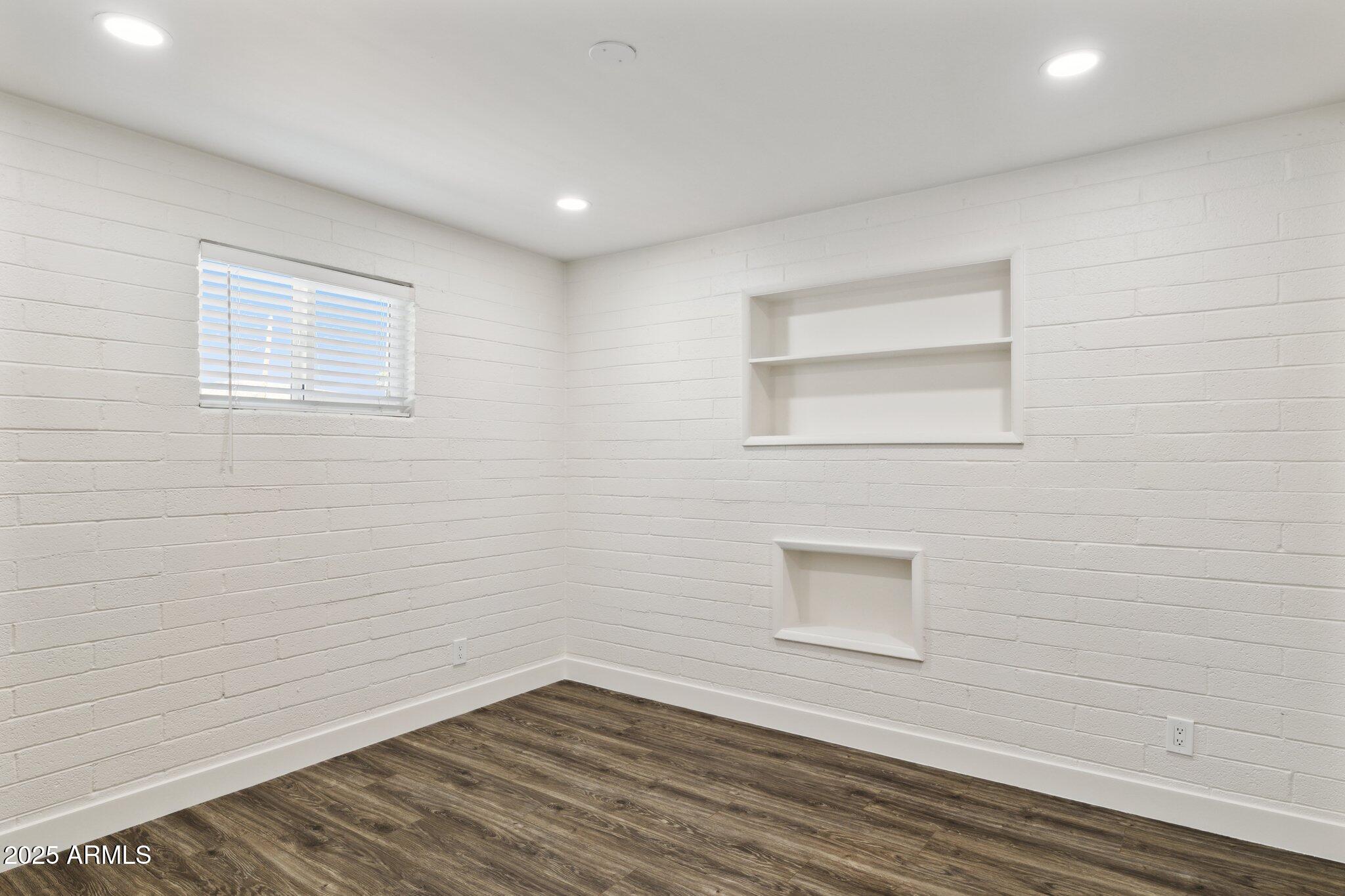 1542 East Turquoise Avenue, Unit 1 Phoenix, AZ 85020 - Photo 16 of 25 a view of an empty room with wooden floor and a window