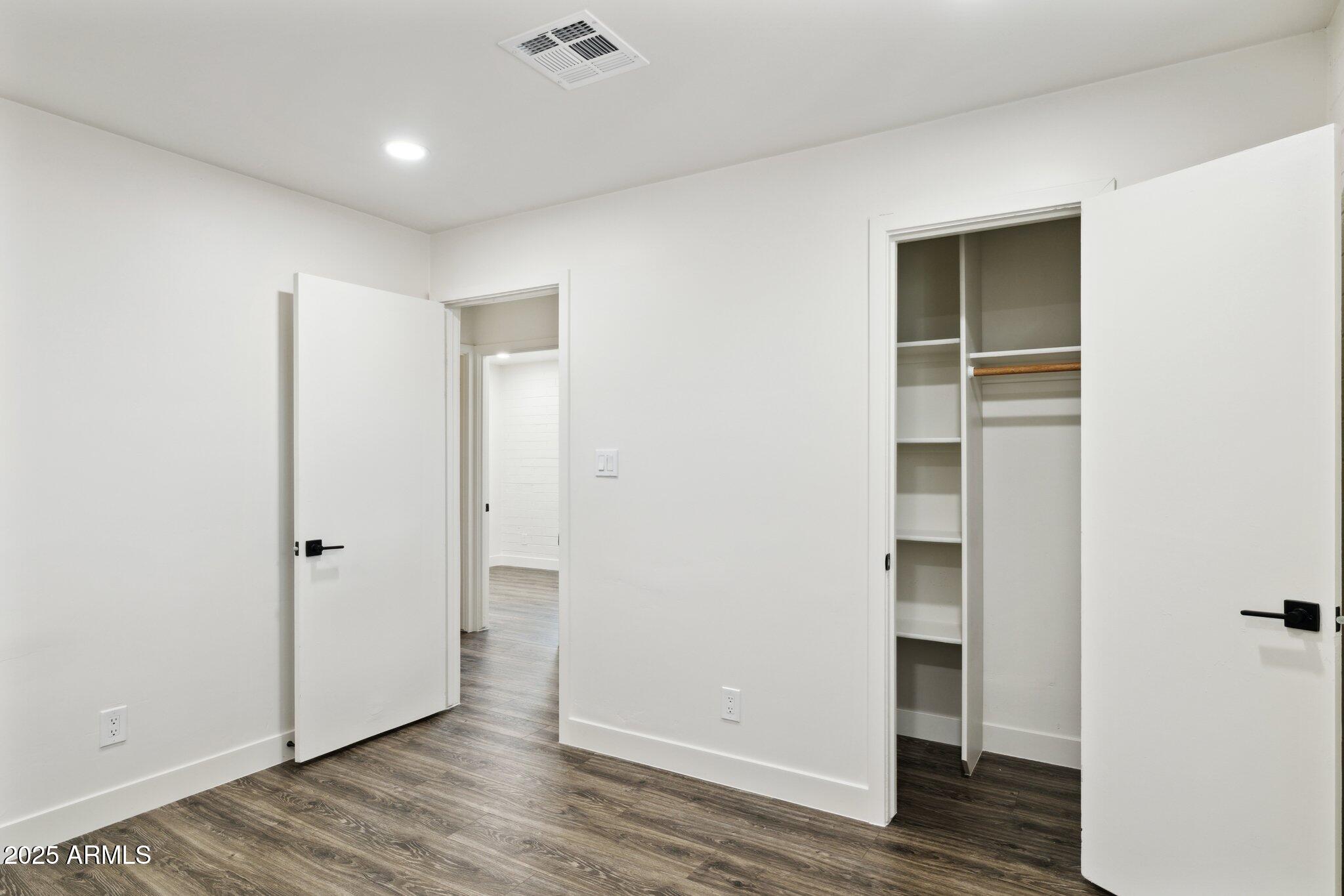 1542 East Turquoise Avenue, Unit 1 Phoenix, AZ 85020 - Photo 17 of 25 an empty room with wooden floor & closet and windows
