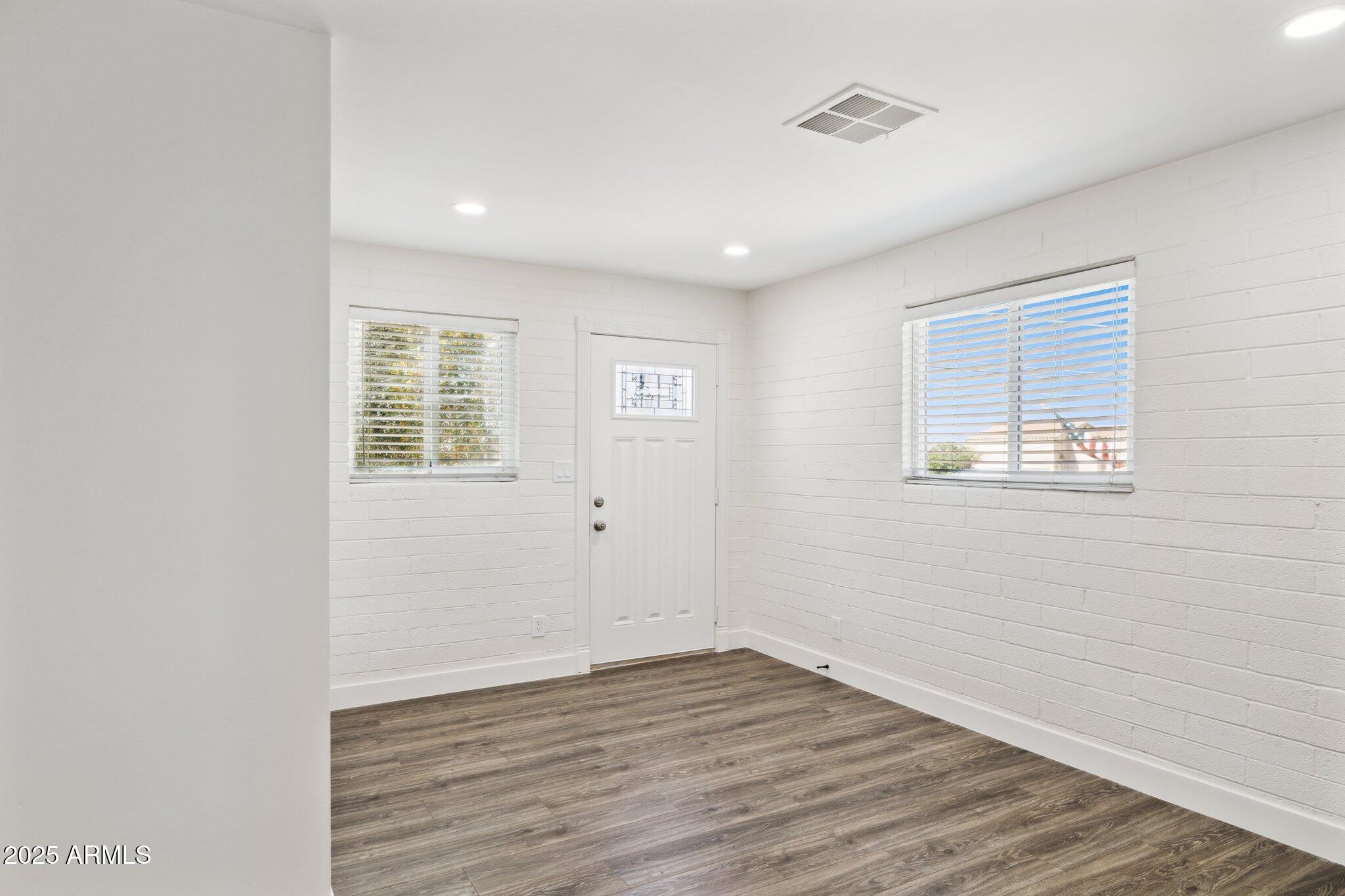 1542 East Turquoise Avenue, Unit 1 Phoenix, AZ 85020 - Photo 4 of 25 an empty room with wooden floor and windows