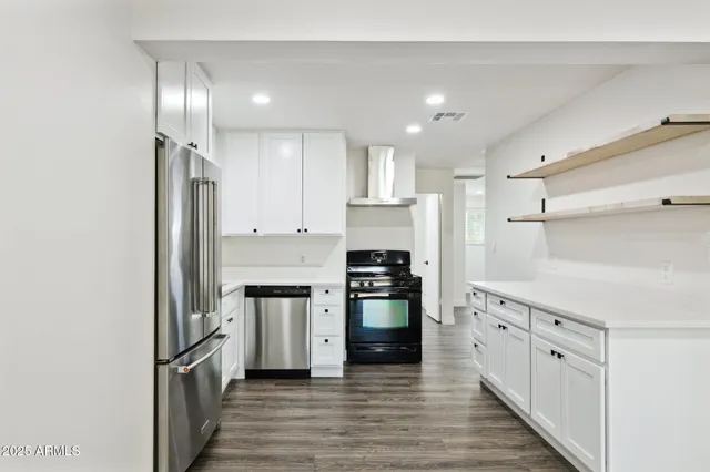 a kitchen with stainless steel appliances granite countertop a refrigerator and a stove top oven