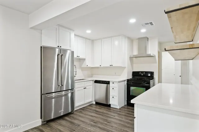 a kitchen with white cabinets and stainless steel appliances