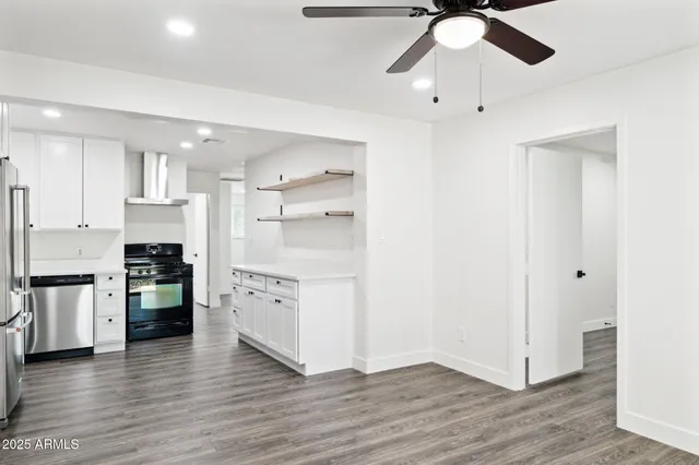 a kitchen with a refrigerator and white cabinets