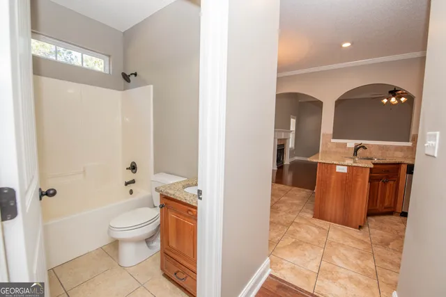 a spacious bathroom with a granite countertop sink a large mirror and a shower