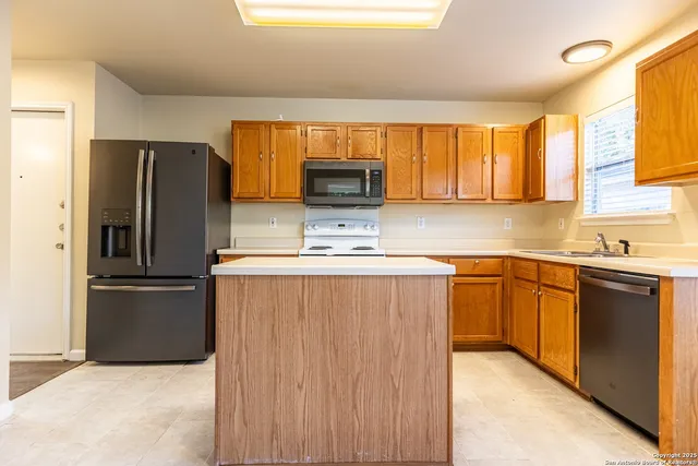 a kitchen with granite countertop a refrigerator and a sink