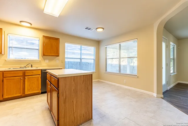 a kitchen with sink and wooden cabinets