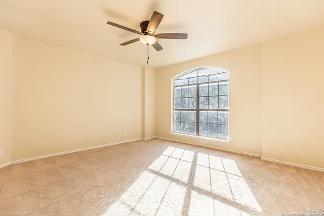 an empty room with windows and fan