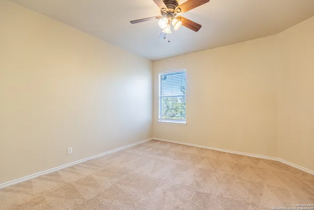 an empty room with a window and a fan