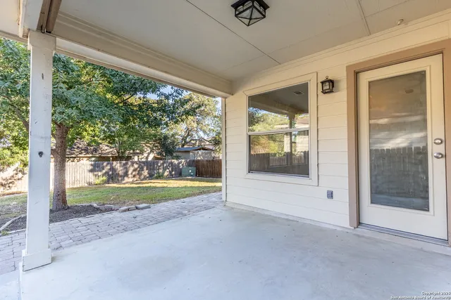 a view of backyard with large windows and plants