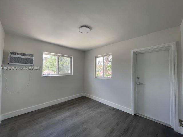 1920 Northwest 151st Street, Unit 3 Opa-Locka, FL 33054 - Photo 4 of 11 a view of an empty room with wooden floor and a window