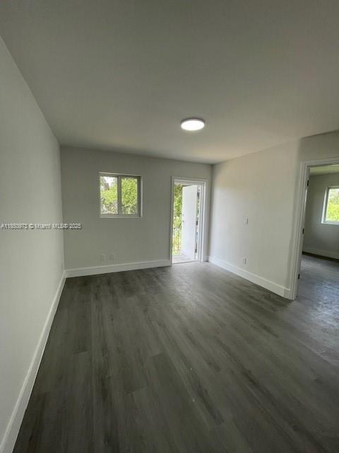 1920 Northwest 151st Street, Unit 3 Opa-Locka, FL 33054 - Photo 5 of 11 an empty room with wooden floor and windows