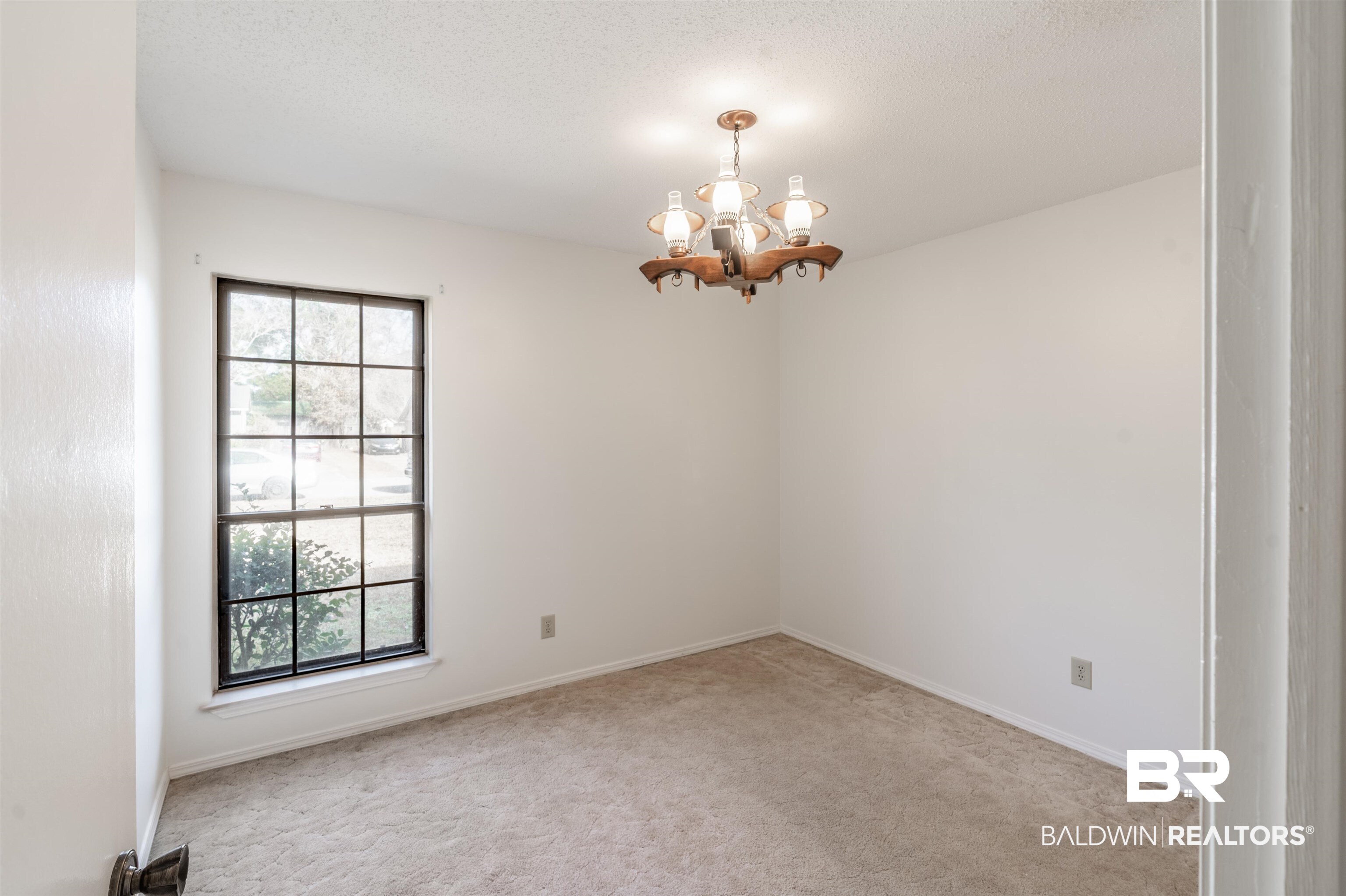 9751 Pine Knoll Road Mobile, AL 36608 - Photo 20 of 36 Empty room with a chandelier, light carpet, and a textured ceiling
