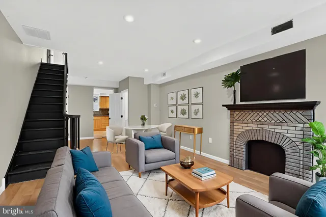a living room with furniture a flat screen tv and a fireplace