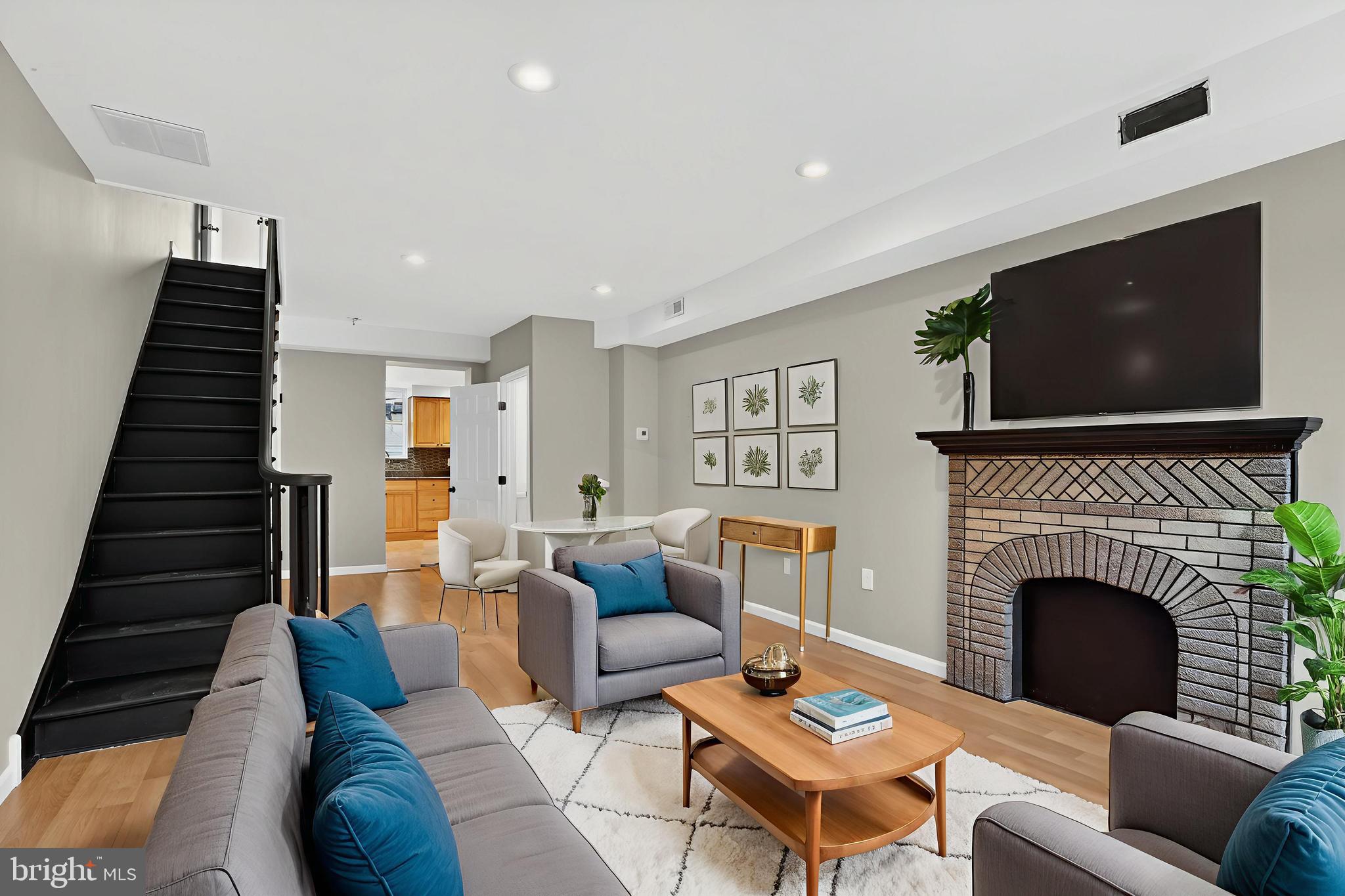 a living room with furniture a flat screen tv and a fireplace