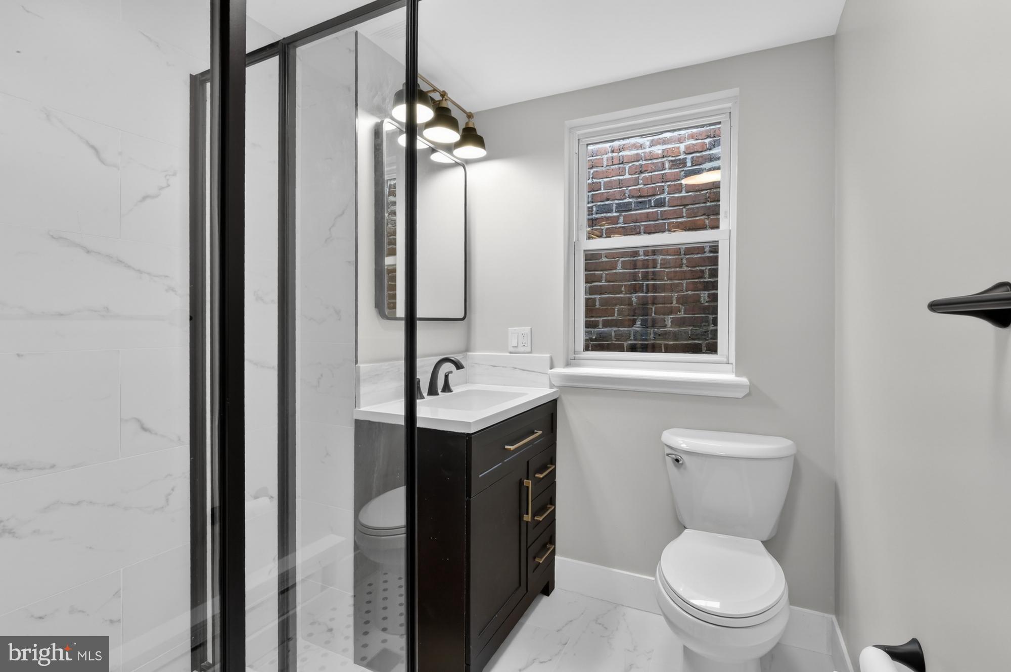 1908 South Jessup Street Philadelphia, PA 19148 - Photo 17 of 28 a bathroom with a granite countertop toilet a sink and a mirror