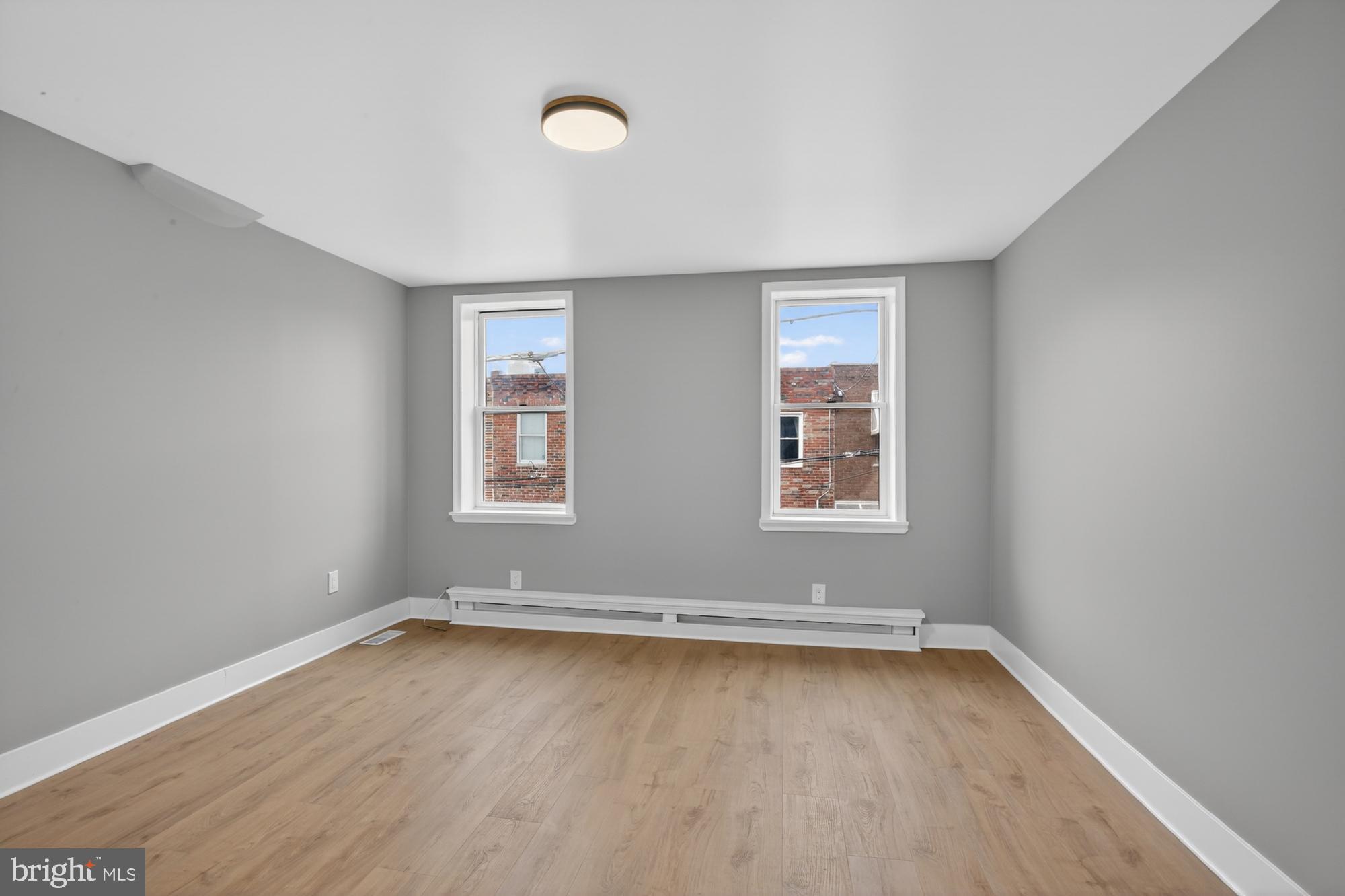1908 South Jessup Street Philadelphia, PA 19148 - Photo 22 of 28 an empty room with wooden floor and windows