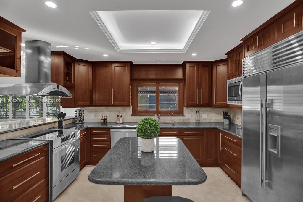 960 Northwest 4th Court Boca Raton, FL 33432 - Photo 25 of 75 a kitchen with kitchen island granite countertop a sink a counter top space appliances and cabinets