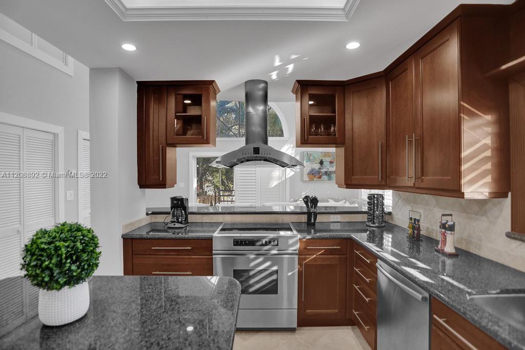 960 Northwest 4th Court Boca Raton, FL 33432 - Photo 26 of 75 a kitchen with stainless steel appliances granite countertop a sink stove and cabinets