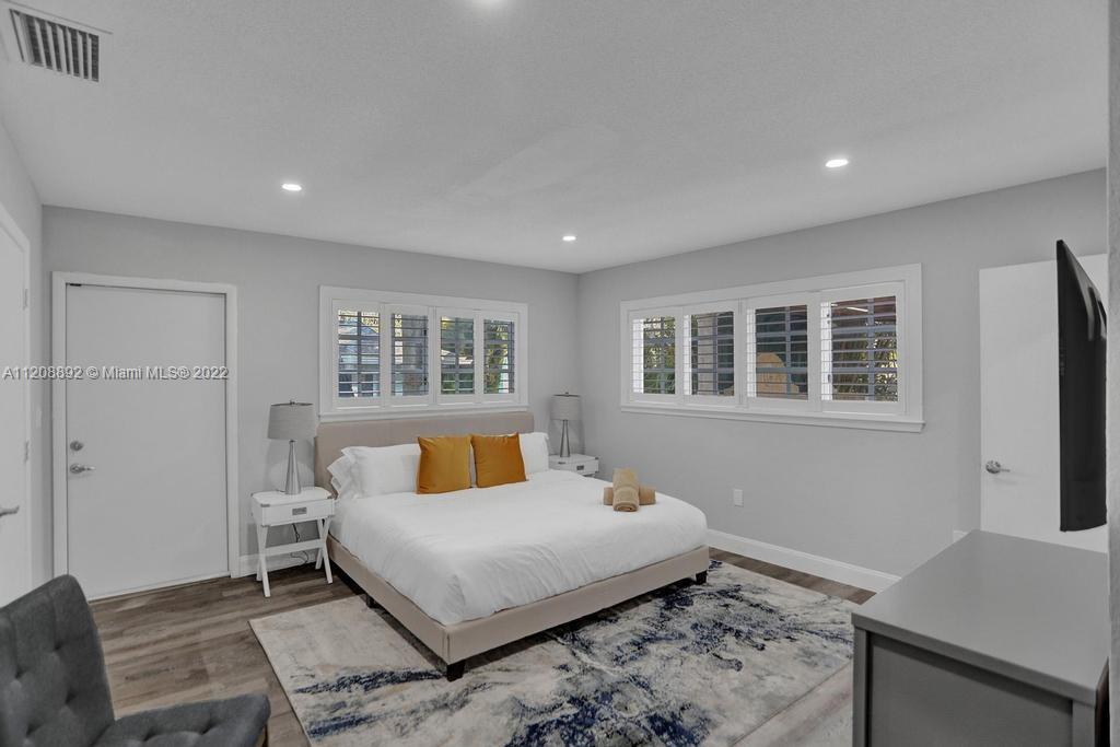 960 Northwest 4th Court Boca Raton, FL 33432 - Photo 36 of 75 a bedroom with a bed and wooden floor